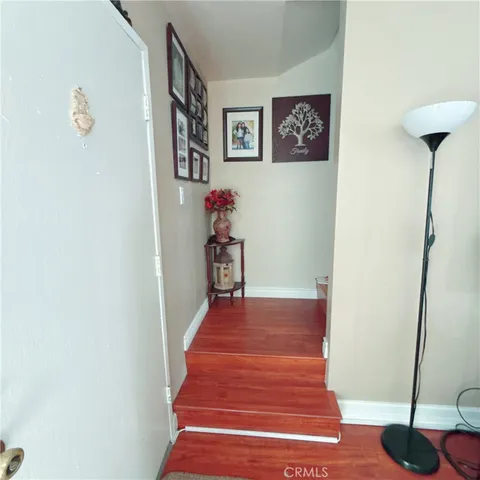 a view of a hallway with wooden floor and a potted plant
