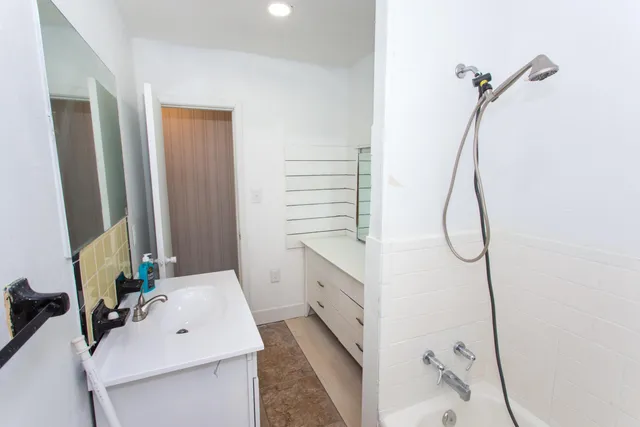 a bathroom with a sink vanity and a mirror