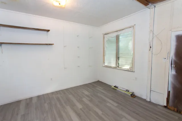 a view of a small space with wooden floor and a window