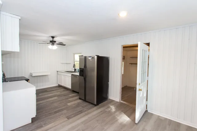a view of a kitchen with a sink and refrigerator