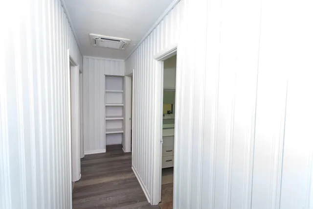 a view of a hallway with wooden floor and entryway