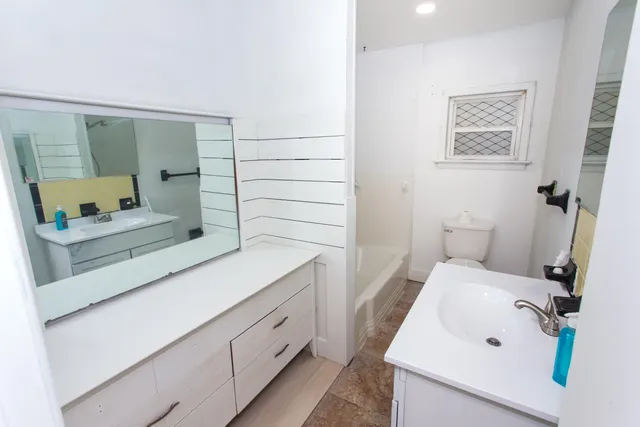 a bathroom with a sink a toilet and mirror