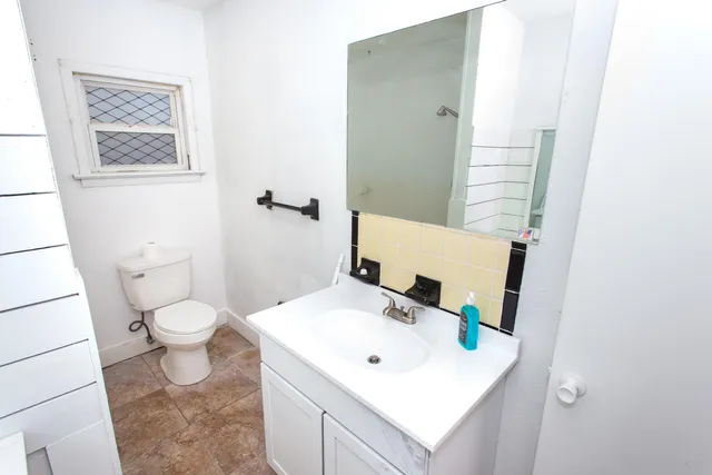 a bathroom with a toilet sink and mirror