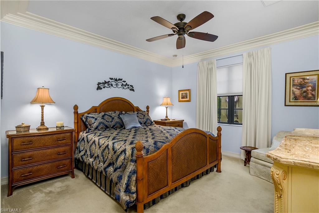 9108 Capistrano Street South, Unit 7402 Naples, FL 34113 - Photo 21 of 50 a bedroom with a bed and a chandelier