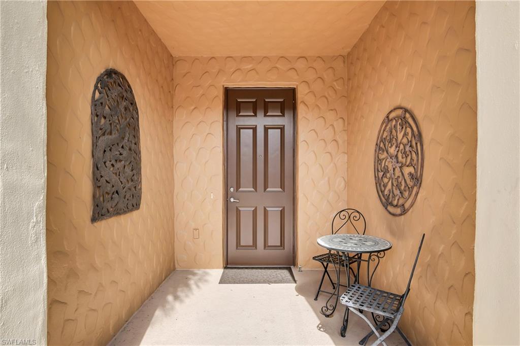 9108 Capistrano Street South, Unit 7402 Naples, FL 34113 - Photo 3 of 50 a front view of a house with table and chairs