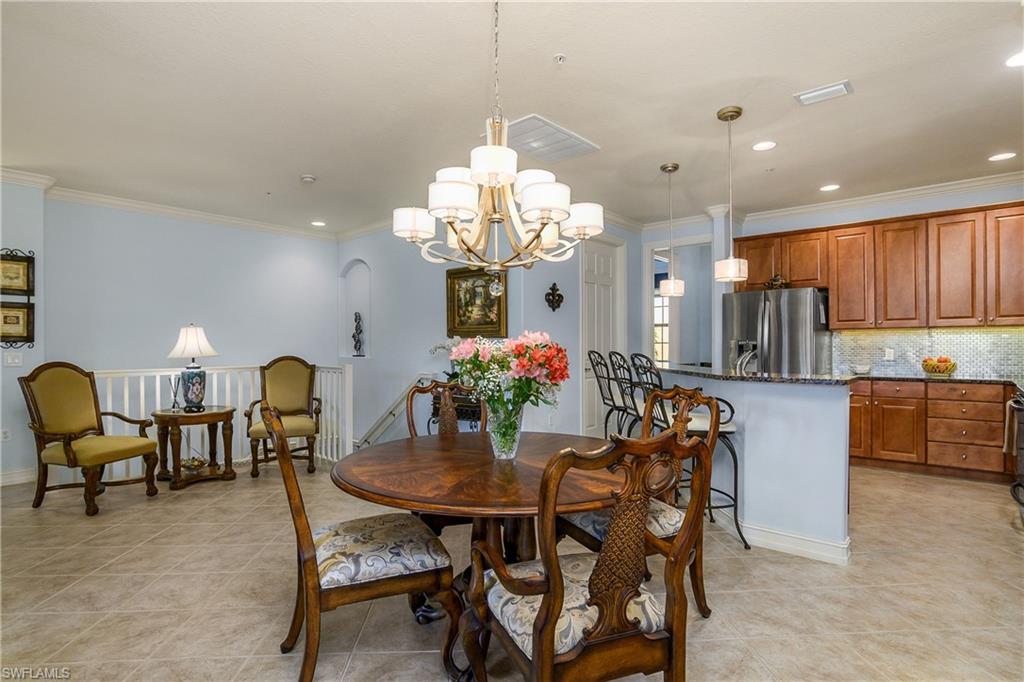 9108 Capistrano Street South, Unit 7402 Naples, FL 34113 - Photo 8 of 50 a dining room filled chandelier and kitchen view