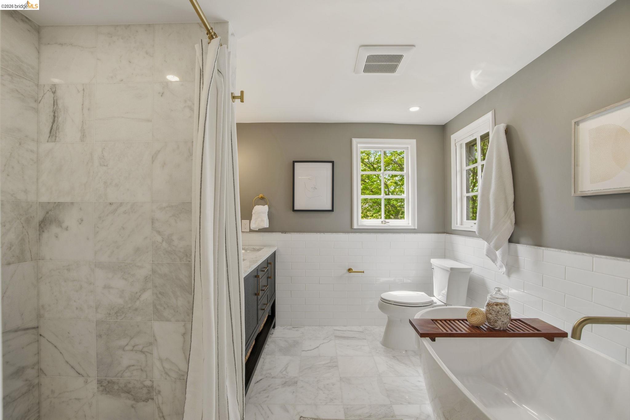 1087 Hubert Road Oakland, CA 94610 - Photo 25 of 67 Marble-tiled shower with a gold-tone shower rod
