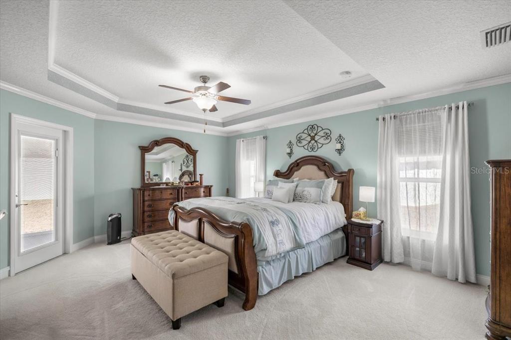 9957 Southwest 55th Ave Road Ocala, FL 34476 - Photo 13 of 41 a bedroom with bed and a chandelier