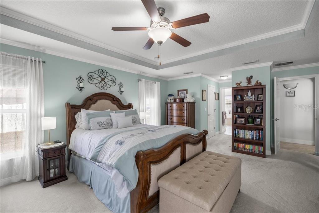 9957 Southwest 55th Ave Road Ocala, FL 34476 - Photo 14 of 41 a bedroom with bed and a chandelier