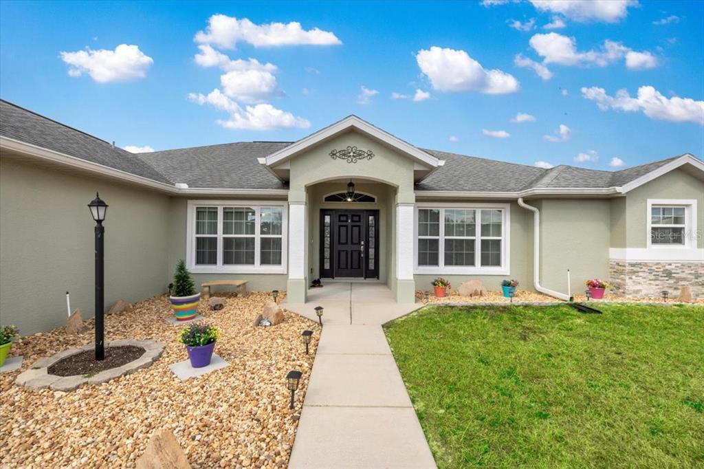 9957 Southwest 55th Ave Road Ocala, FL 34476 - Photo 2 of 41 a front view of a house with a yard