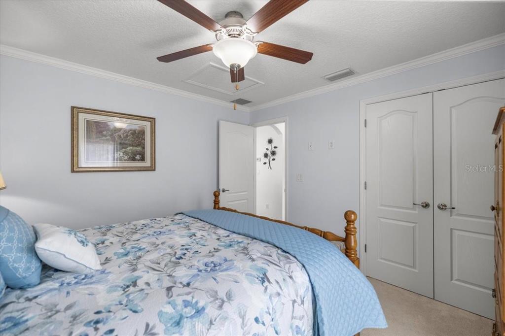 9957 Southwest 55th Ave Road Ocala, FL 34476 - Photo 22 of 41 a bedroom with a large bed and a chandelier