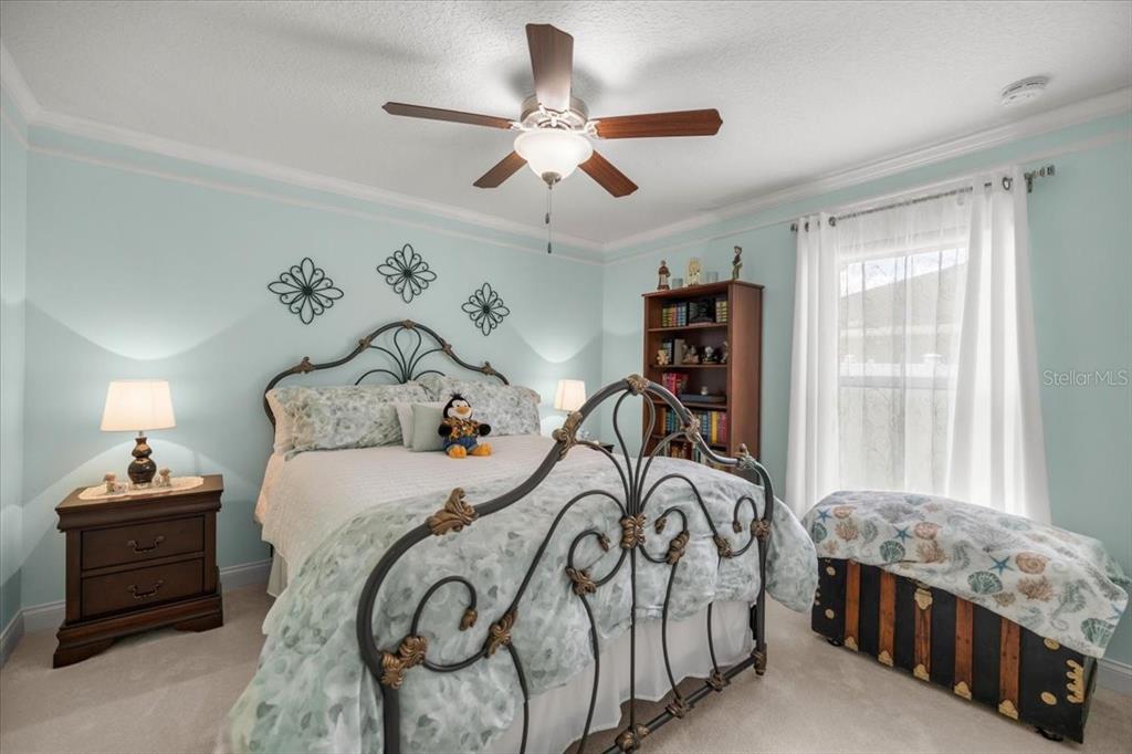 9957 Southwest 55th Ave Road Ocala, FL 34476 - Photo 24 of 41 a bedroom with a bed and a chandelier