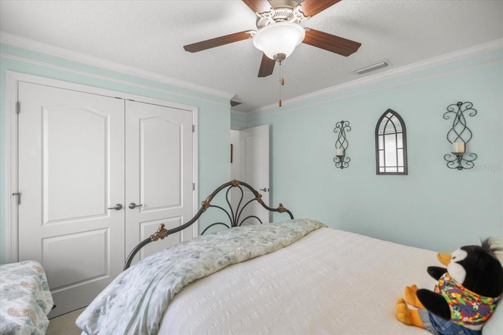 9957 Southwest 55th Ave Road Ocala, FL 34476 - Photo 25 of 41 a bedroom with a bed and a chandelier