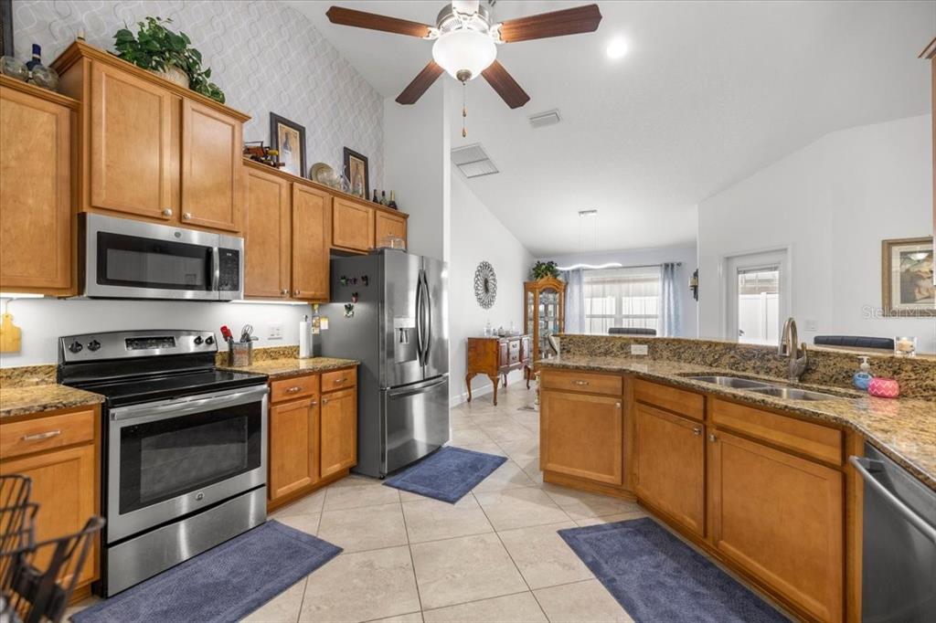 9957 Southwest 55th Ave Road Ocala, FL 34476 - Photo 9 of 41 a large kitchen with stainless steel appliances granite countertop a stove refrigerator sink and dishwasher
