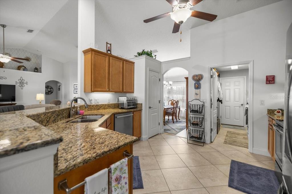 9957 Southwest 55th Ave Road Ocala, FL 34476 - Photo 10 of 41 a kitchen with stainless steel appliances granite countertop a sink refrigerator and cabinets