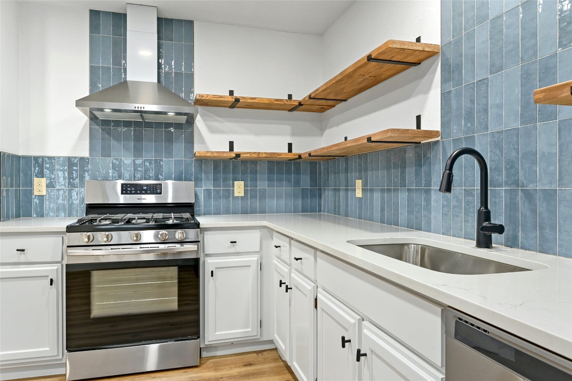 a kitchen with cabinets a sink and stainless steel appliances