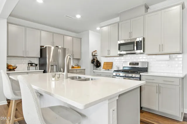 a large kitchen with kitchen island a dining table and chairs