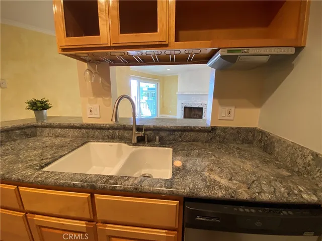 a kitchen with granite countertop a sink and a wooden cabinets