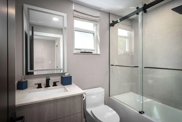 a bathroom with a granite countertop sink toilet and shower