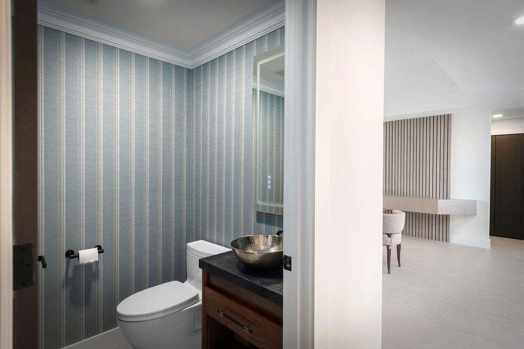 17031 Boca Club Boulevard, Unit 65A Boca Raton, FL 33487 - Photo 23 of 34 a bathroom with a toilet a sink and shower