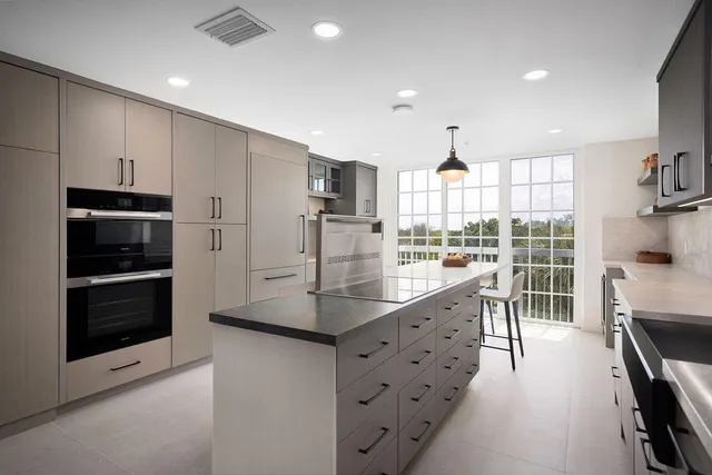 a kitchen with kitchen island granite countertop a stove a sink and a refrigerator