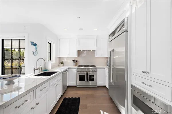 a kitchen with white cabinets and stainless steel appliances