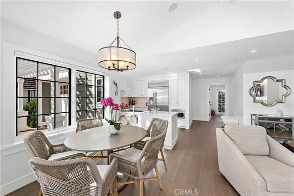 a dining room with furniture a chandelier and wooden floor