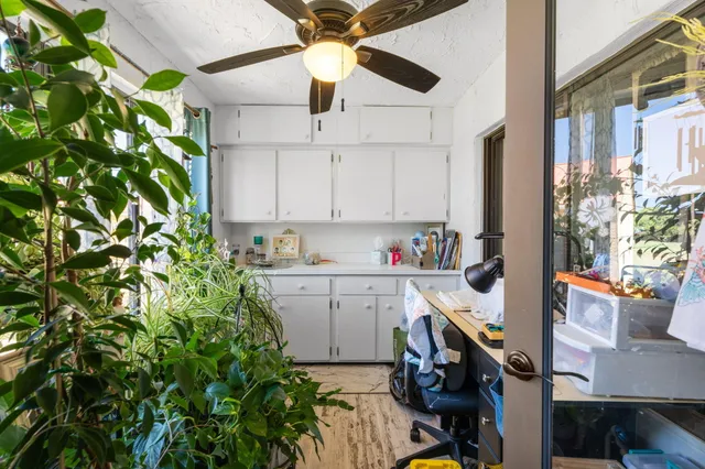 a kitchen that has a lot of white cabinets and appliances