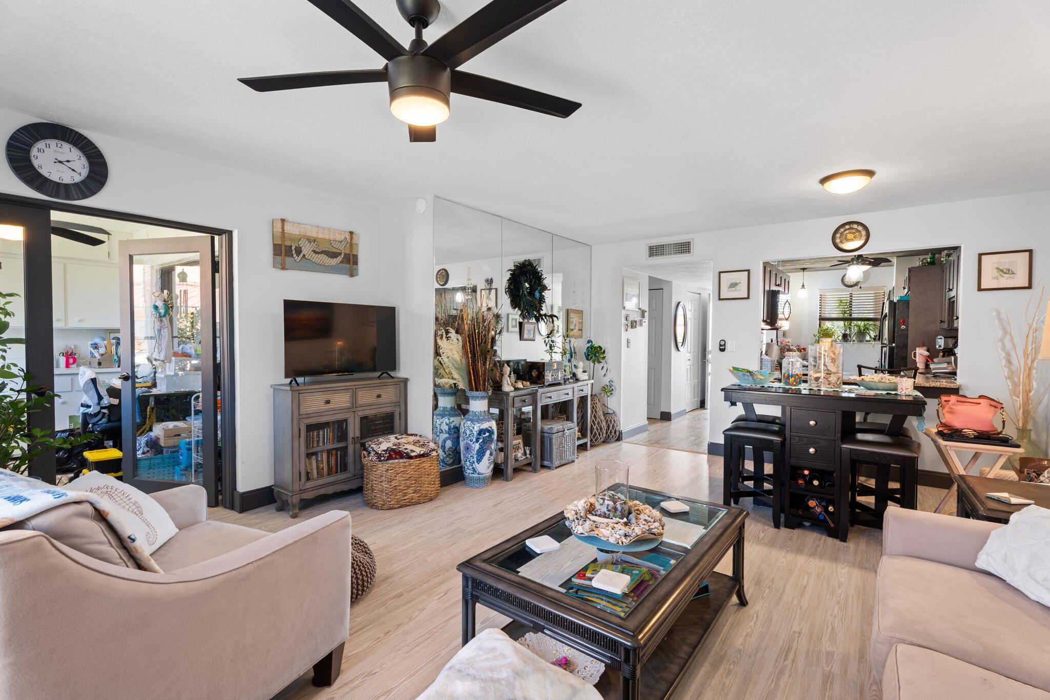 5383 Southeast Miles Grant Road, Unit B206 Stuart, FL 34997 - Photo 12 of 17 a living room with furniture and a flat screen tv with wooden floor