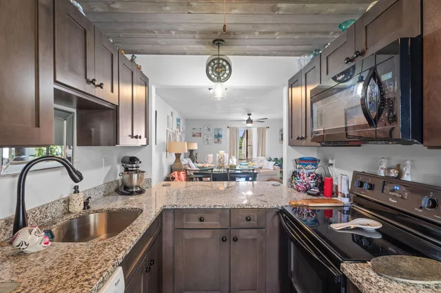 a kitchen with stainless steel appliances granite countertop a sink a stove and cabinets