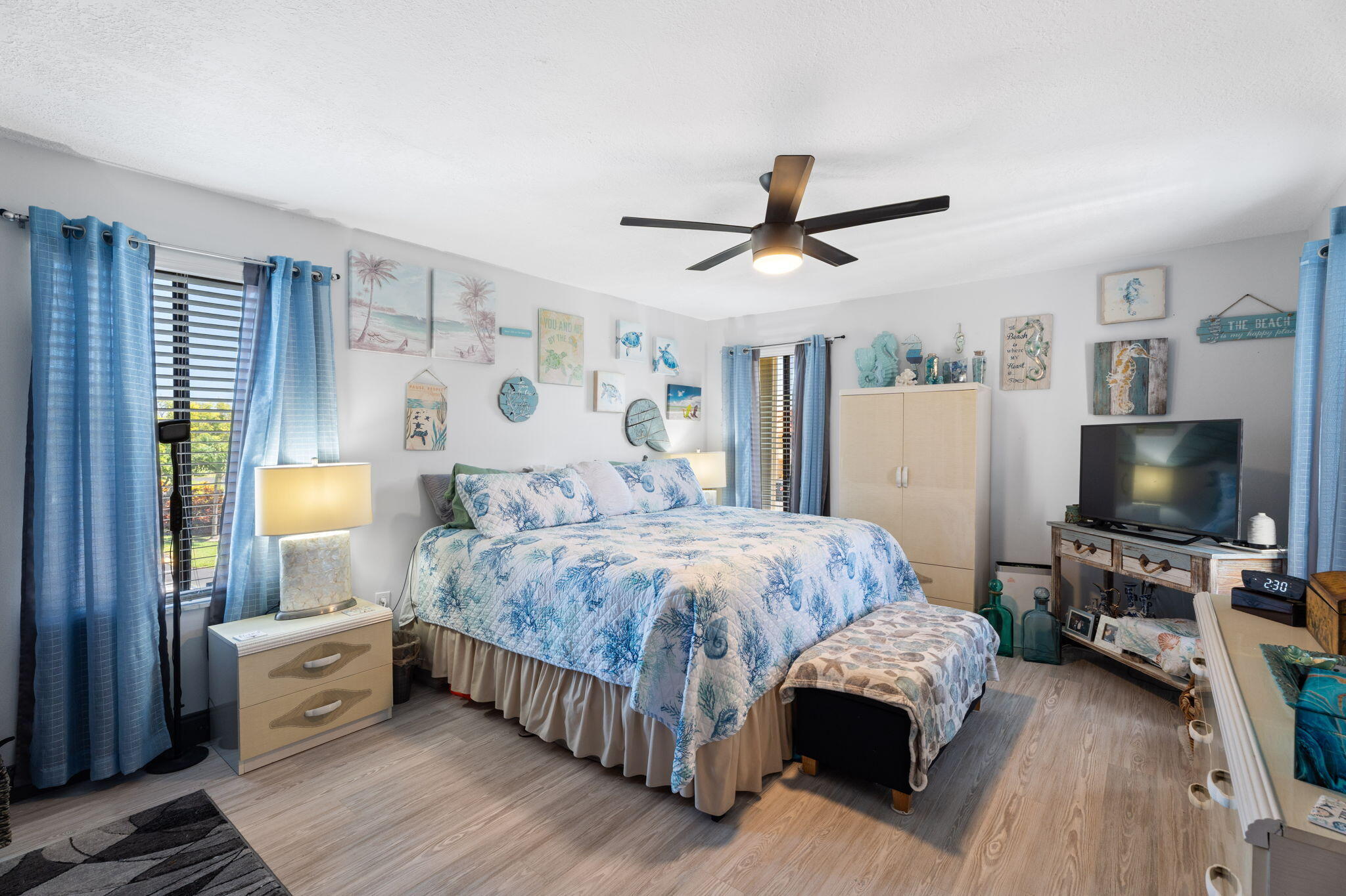 5383 Southeast Miles Grant Road, Unit B206 Stuart, FL 34997 - Photo 8 of 17 a spacious bedroom with a bed and a flat screen tv