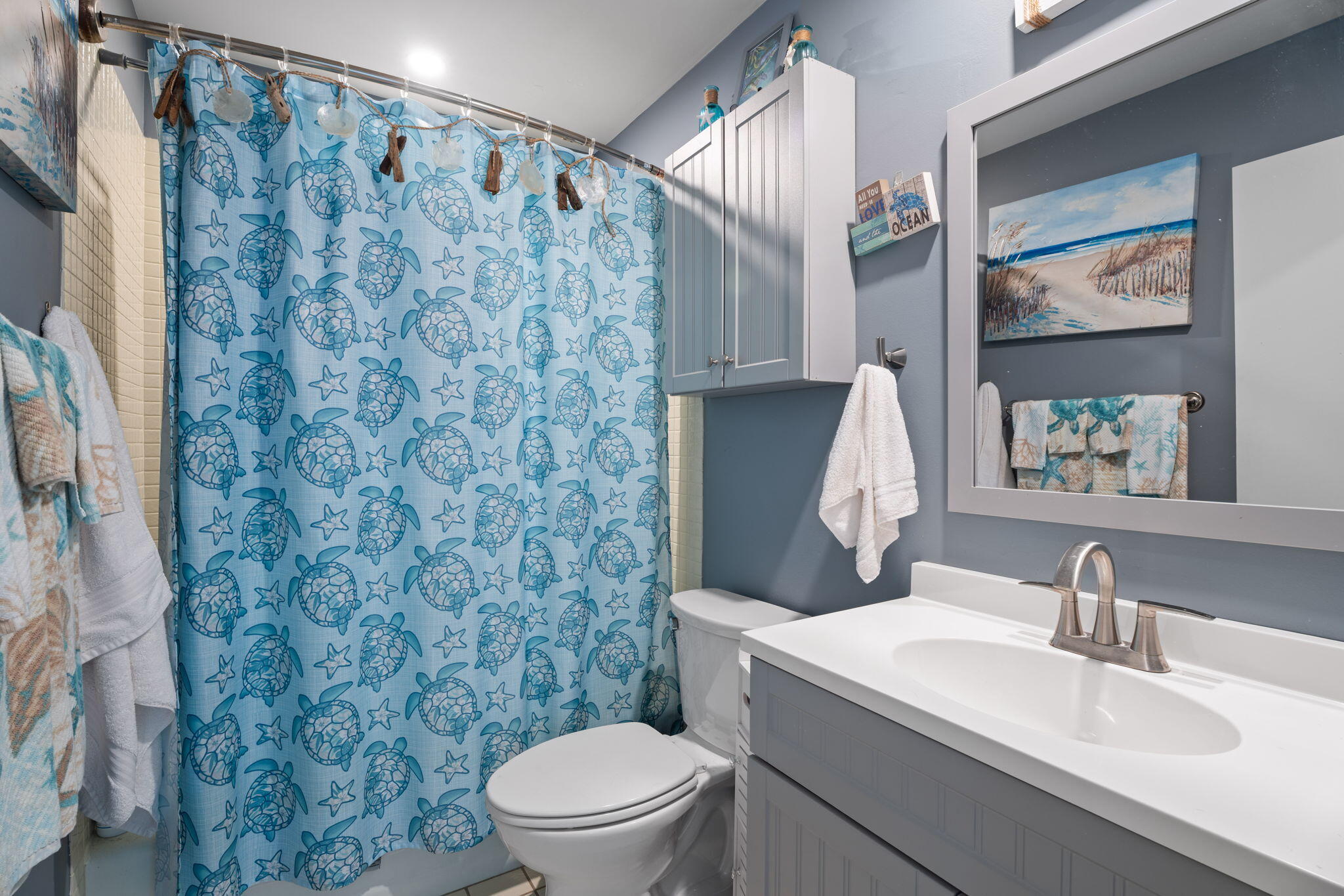 5383 Southeast Miles Grant Road, Unit B206 Stuart, FL 34997 - Photo 10 of 17 a bathroom with a sink a toilet and a mirror
