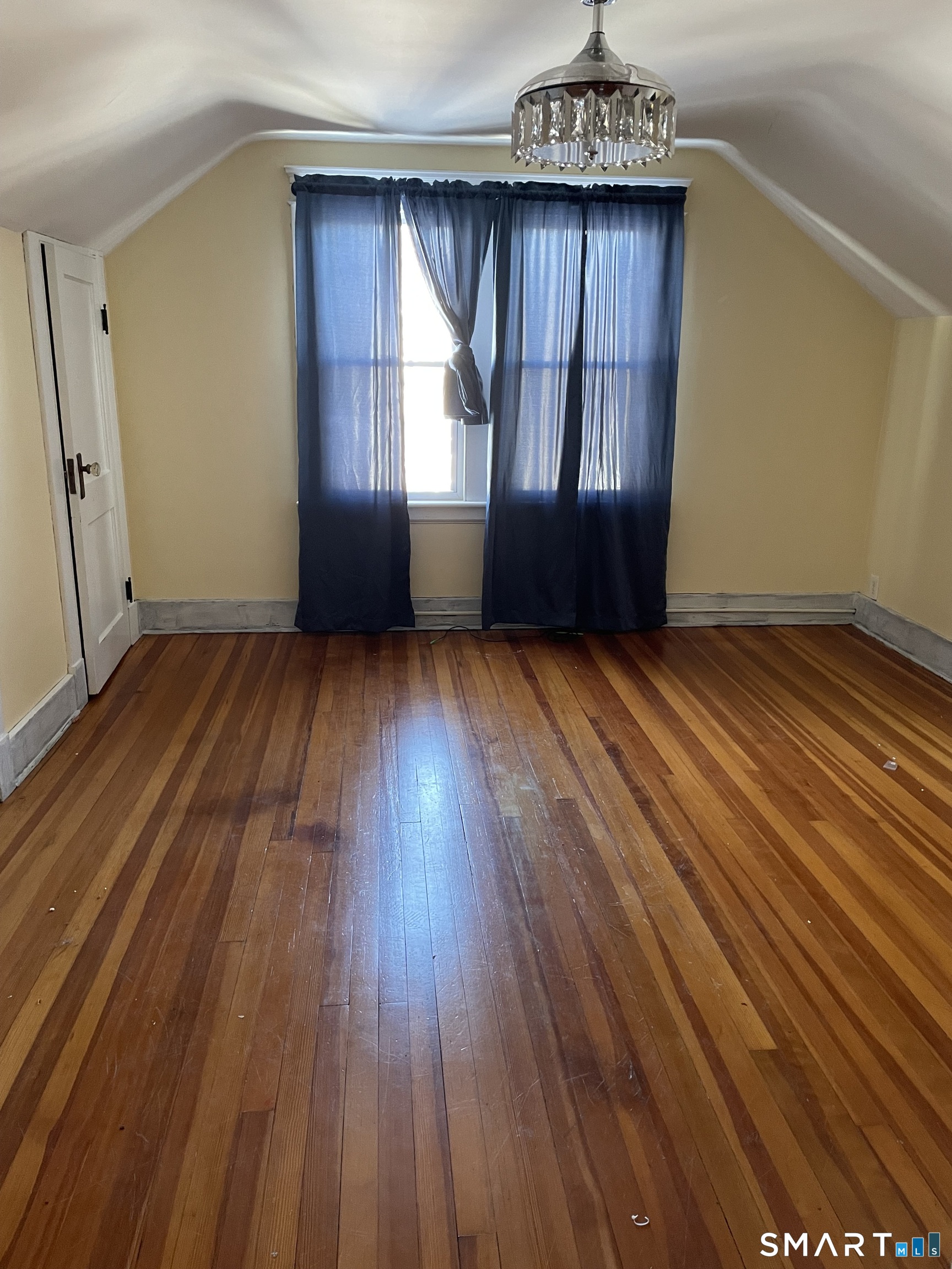 13-15 Crescent Street, Unit 3 Ansonia, CT 06401 - Photo 3 of 4 an empty room with wooden floor and windows