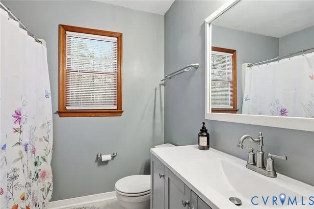 a bathroom with a sink vanity mirror and toilet