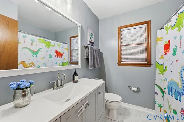 a bathroom with a sink mirror and toilet
