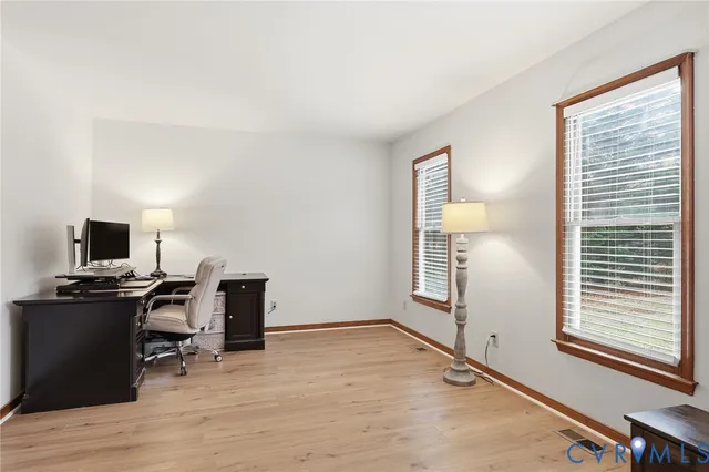 a view of a workspace with furniture and a window