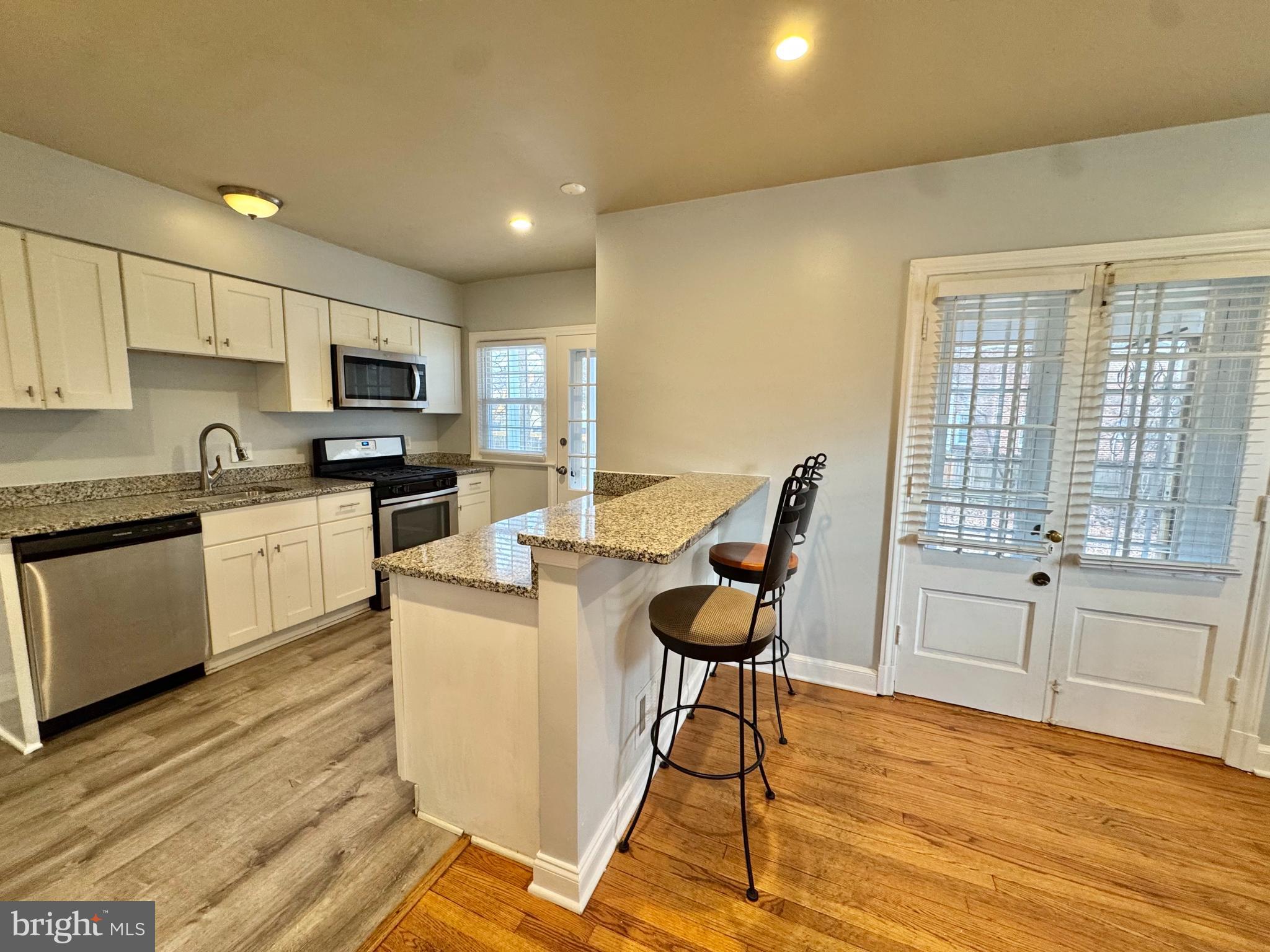 8815 Reading Road Silver Spring, MD 20901 - Photo 11 of 56 a kitchen with kitchen island a stove a sink a dining table and chairs