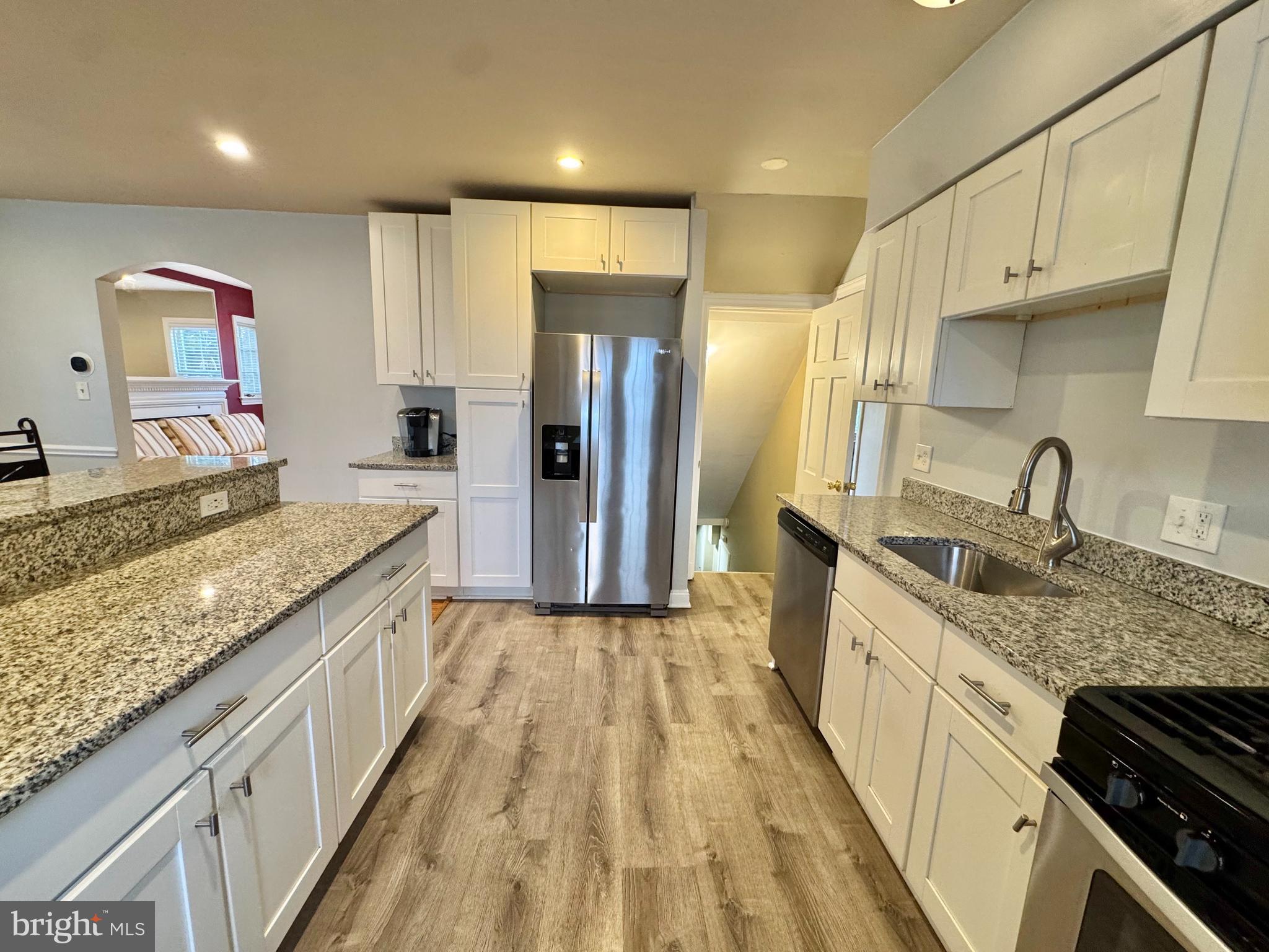 8815 Reading Road Silver Spring, MD 20901 - Photo 16 of 56 a large kitchen with granite countertop a large counter top wooden cabinets and stainless steel appliances