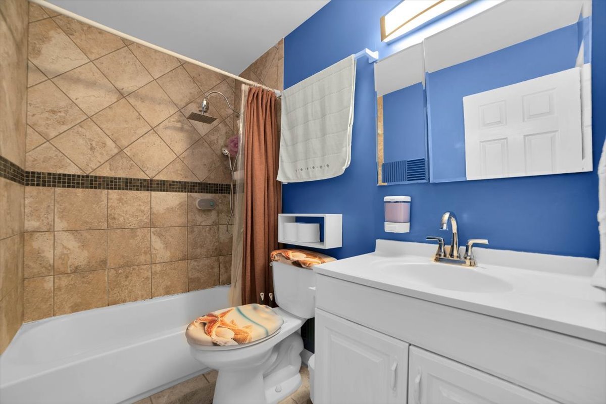 500 West Huntington Commons Road, Unit 448 Mount Prospect, IL 60056 - Photo 13 of 26 a bathroom with a sink a toilet and mirror