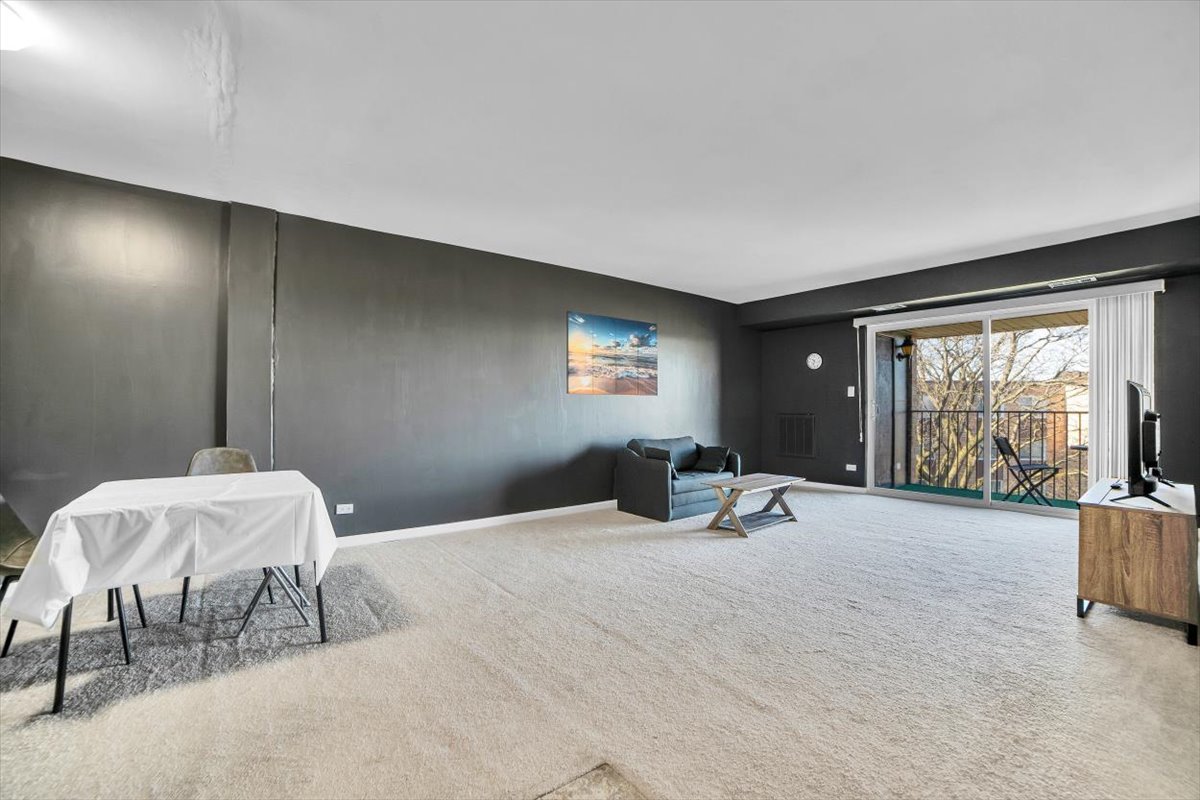 500 West Huntington Commons Road, Unit 448 Mount Prospect, IL 60056 - Photo 2 of 26 a bedroom with a bed and a large window