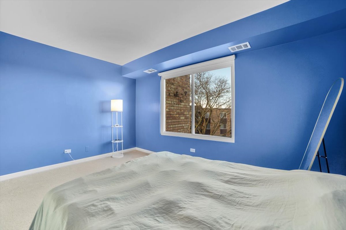 500 West Huntington Commons Road, Unit 448 Mount Prospect, IL 60056 - Photo 10 of 26 a bedroom with a bed and a window
