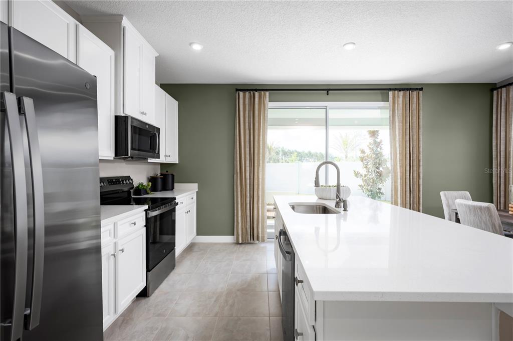 31590 Spanish Msn Road San Antonio, FL 33576 - Photo 7 of 26 a kitchen with a sink a refrigerator and a stove top oven