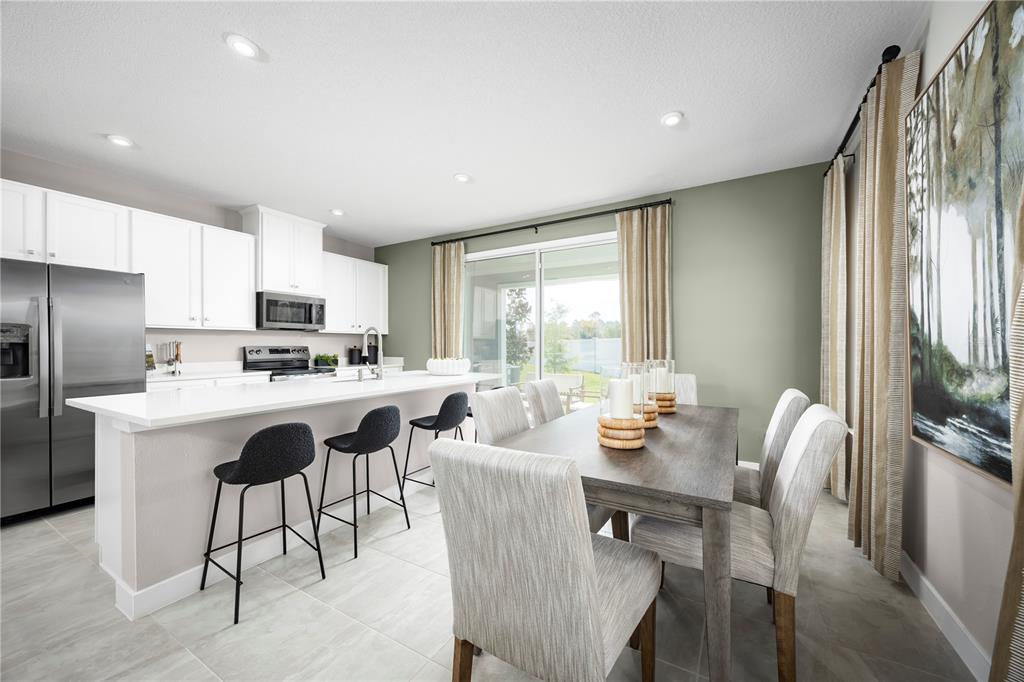 31590 Spanish Msn Road San Antonio, FL 33576 - Photo 9 of 26 a living room with stainless steel appliances granite countertop furniture a fireplace a flat screen tv and a refrigerator