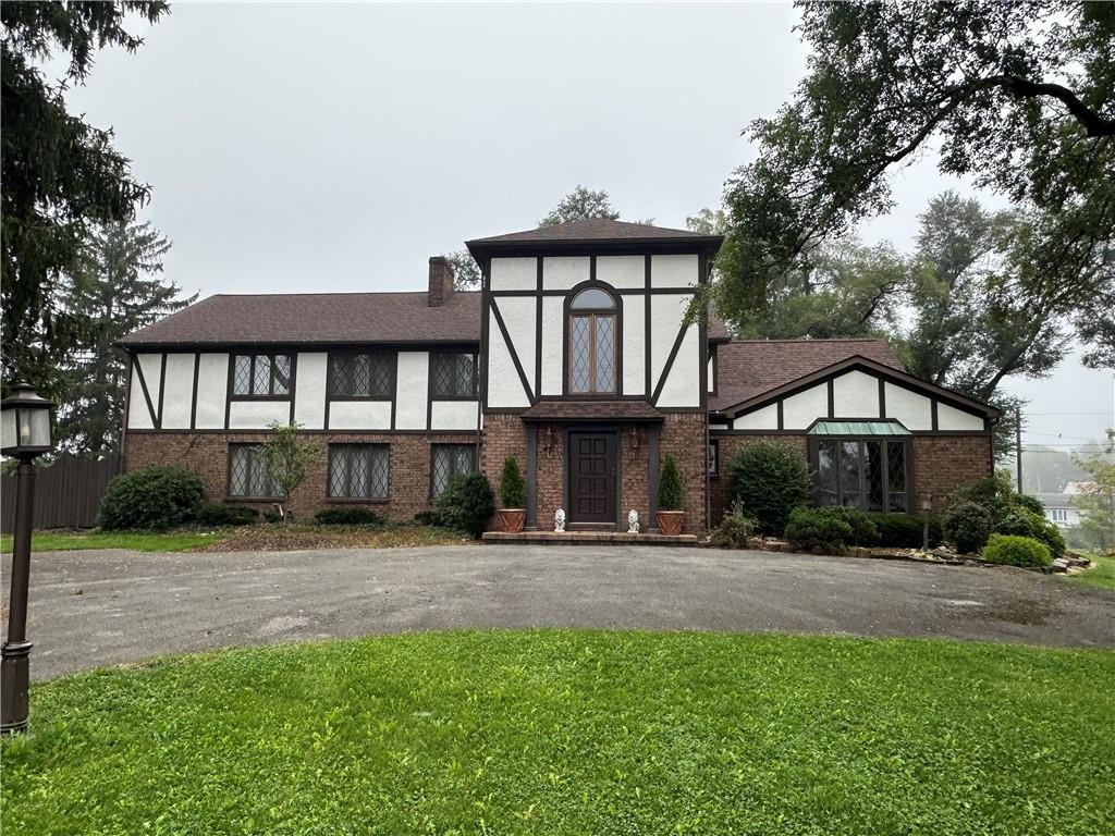 a front view of a house with yard and green space