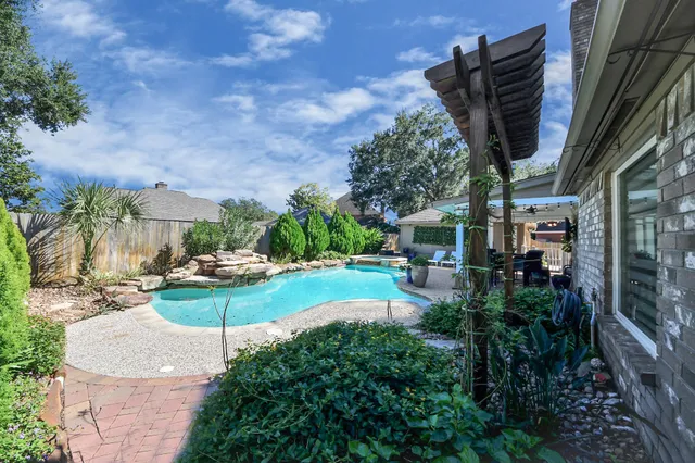 a dining room with chandelier and wooden floor