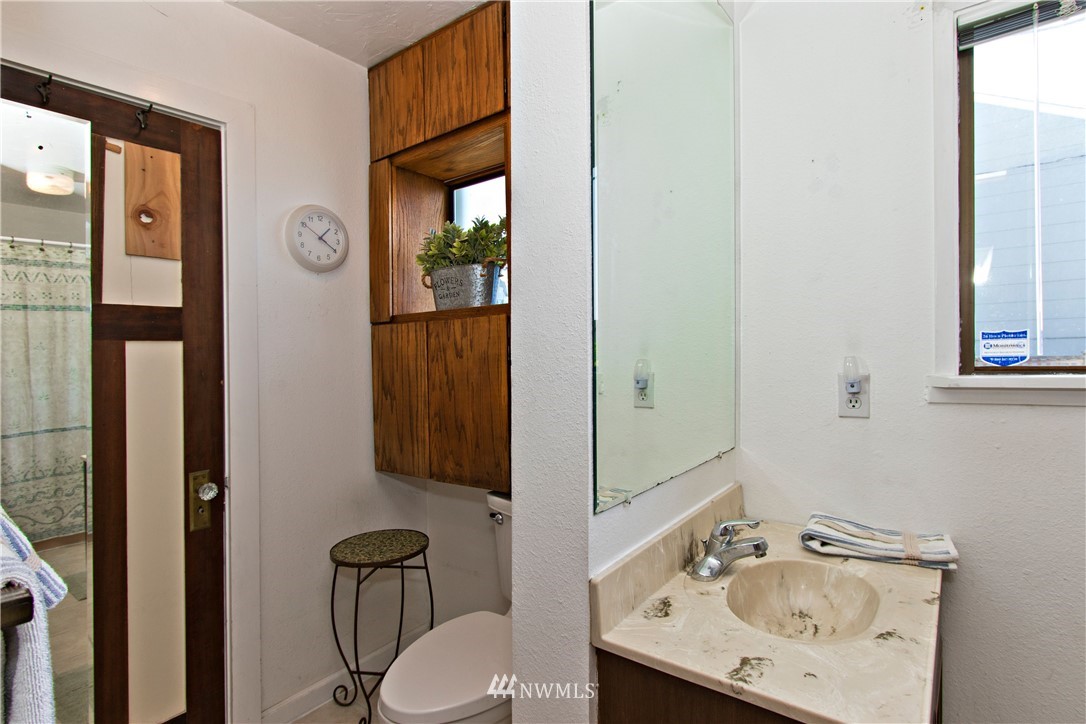 7501 California Avenue Southwest Seattle, WA 98136 - Photo 12 of 25 a bathroom with a sink a toilet and mirror