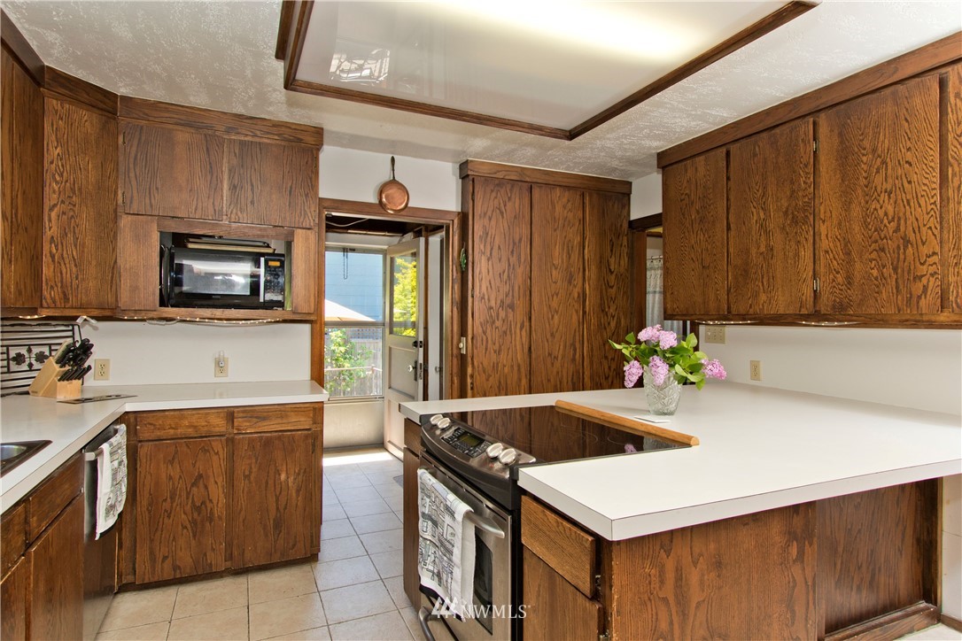 7501 California Avenue Southwest Seattle, WA 98136 - Photo 9 of 25 a kitchen that has a sink and a stove in it