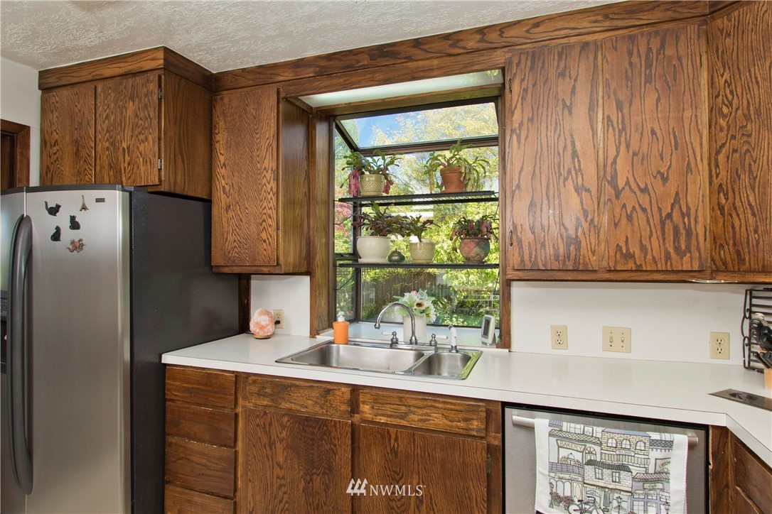 7501 California Avenue Southwest Seattle, WA 98136 - Photo 10 of 25 a kitchen with a sink a refrigerator and cabinets