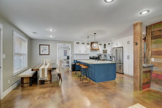 a large living room with stainless steel appliances kitchen island granite countertop furniture and a living room