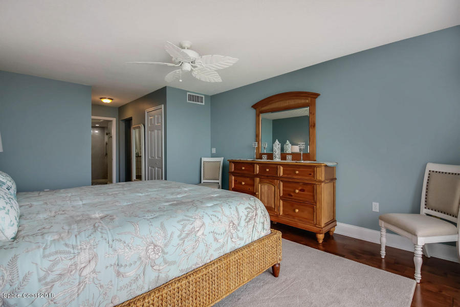3400 Ocean Beach Boulevard, Unit 309 Cocoa Beach, FL 32931 - Photo 16 of 27 a bedroom with a bed and a chandelier